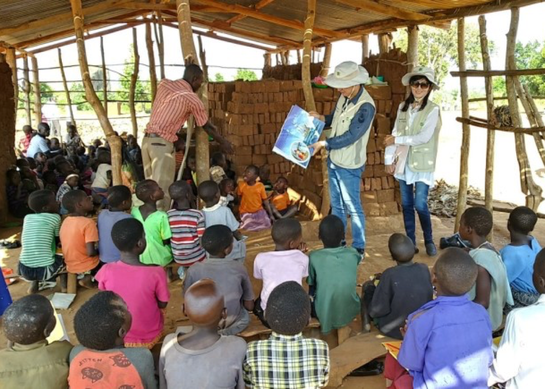 Reading books to children in Busamu village